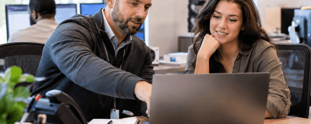 Employees collaborating on technology solutions in a modern office environment.