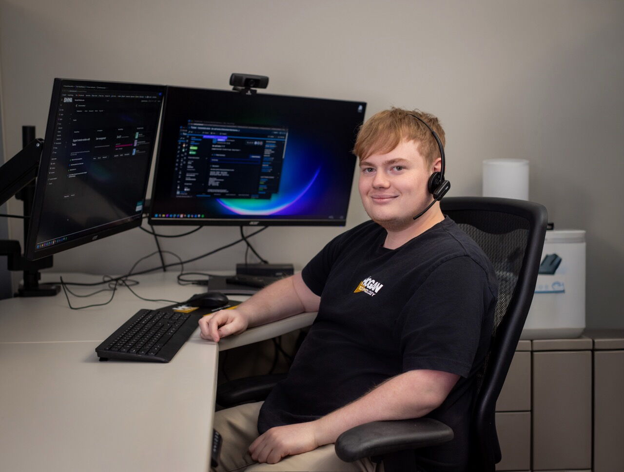 Man Sitting at Computer Desk with Earpiece