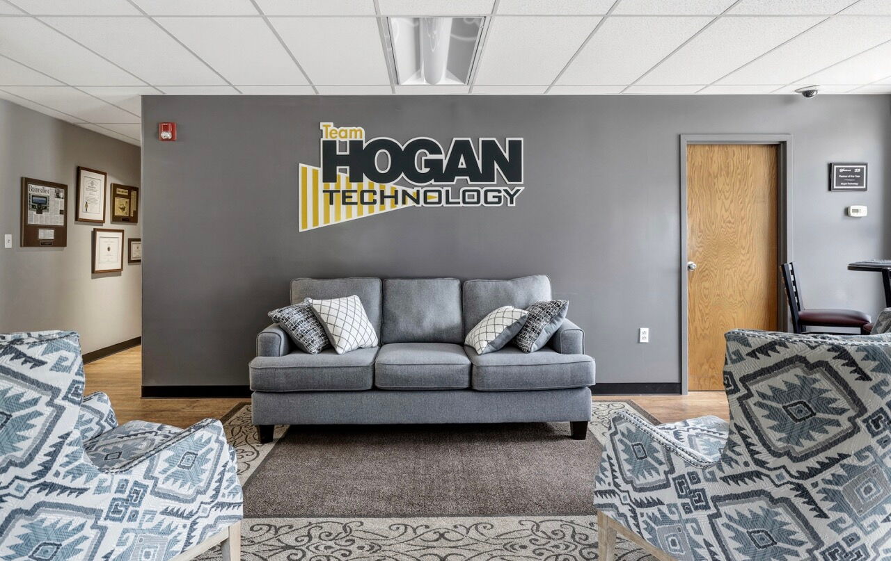 Couch beneath Team Hogan Technology sign